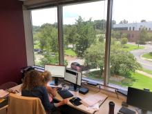 Executive Director, Carrie Pettus-Davis, working at HQ with her daughter in her lap.